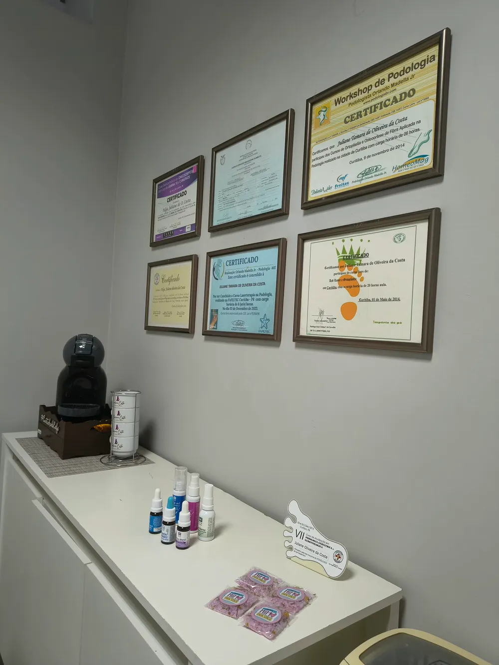 Outro ângulo da sala da Juliane, com bancada e certificados na parede